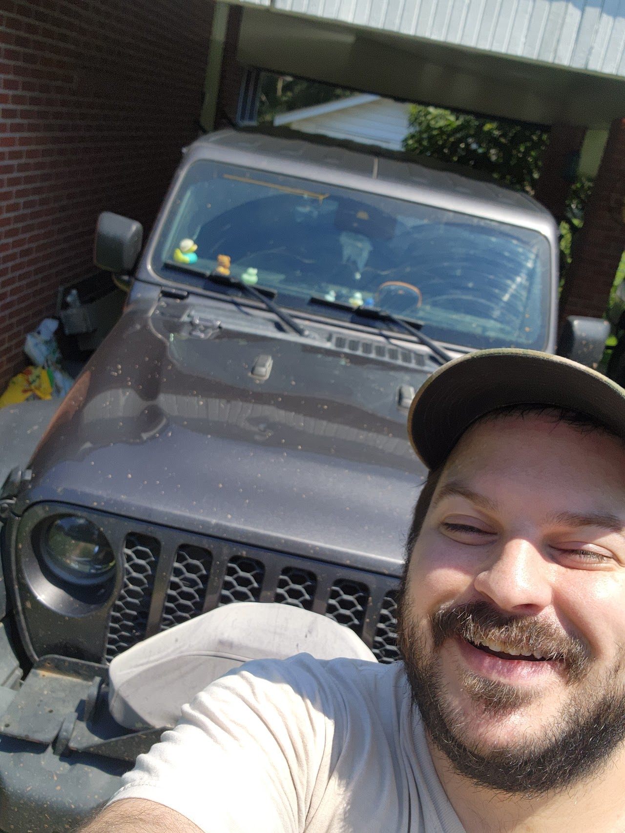 Spencer Callicott with a gray Jeep Wrangler on a sunny day