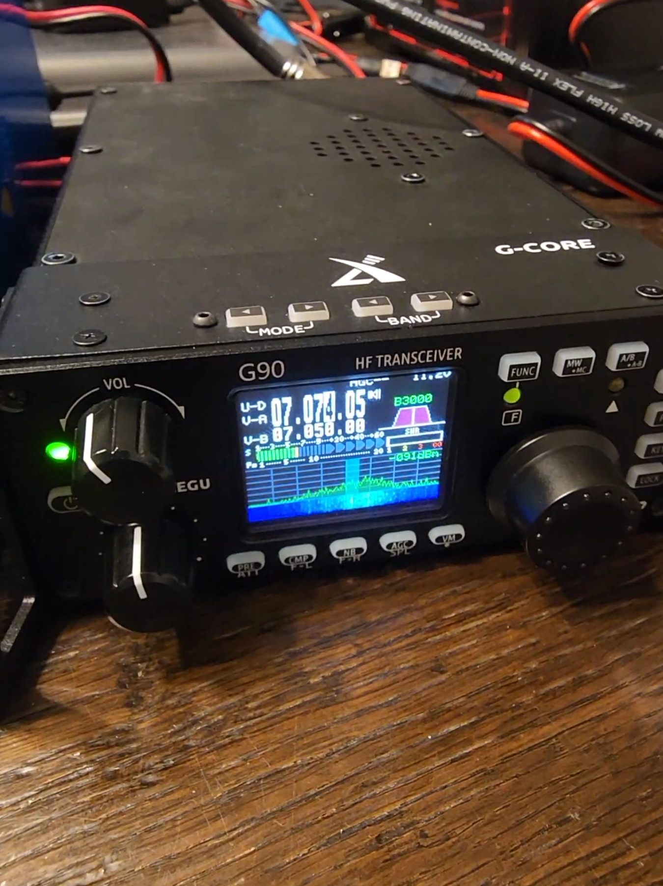 Xiegu G90 HF transceiver with spectrum display showing active signal